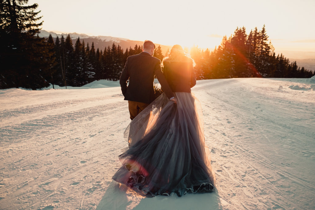 A couple walks into the sunset in the snow after their Vail Colorado elopement.